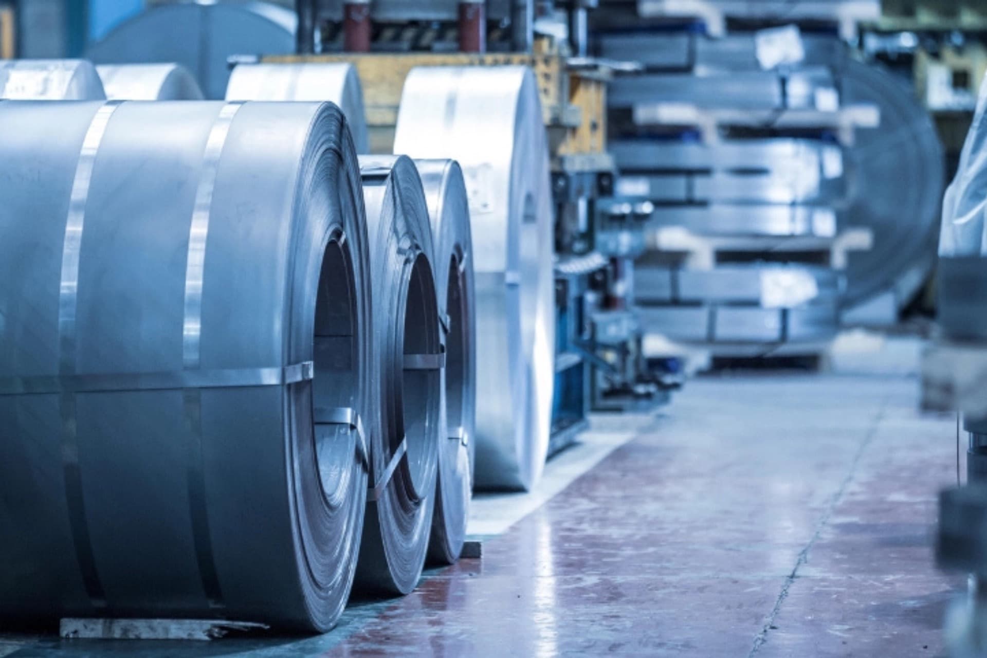 Industrial metal rolls in a factory representing direct materials